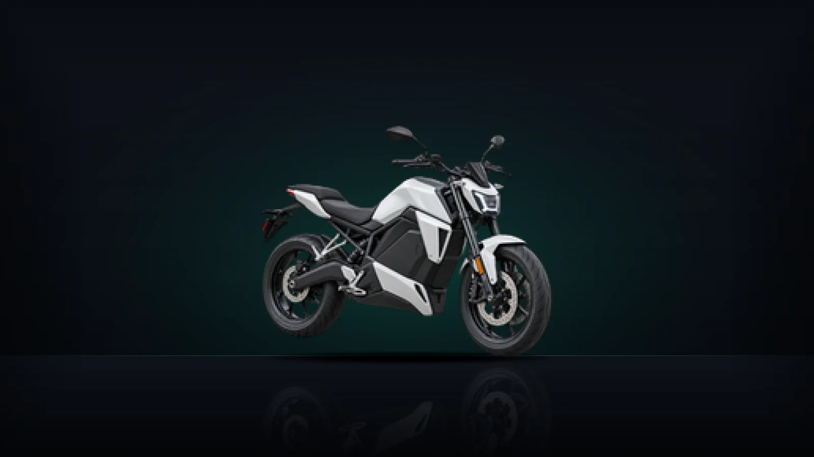 A white electric motorcycle on a dark floor with a soft green light behind it