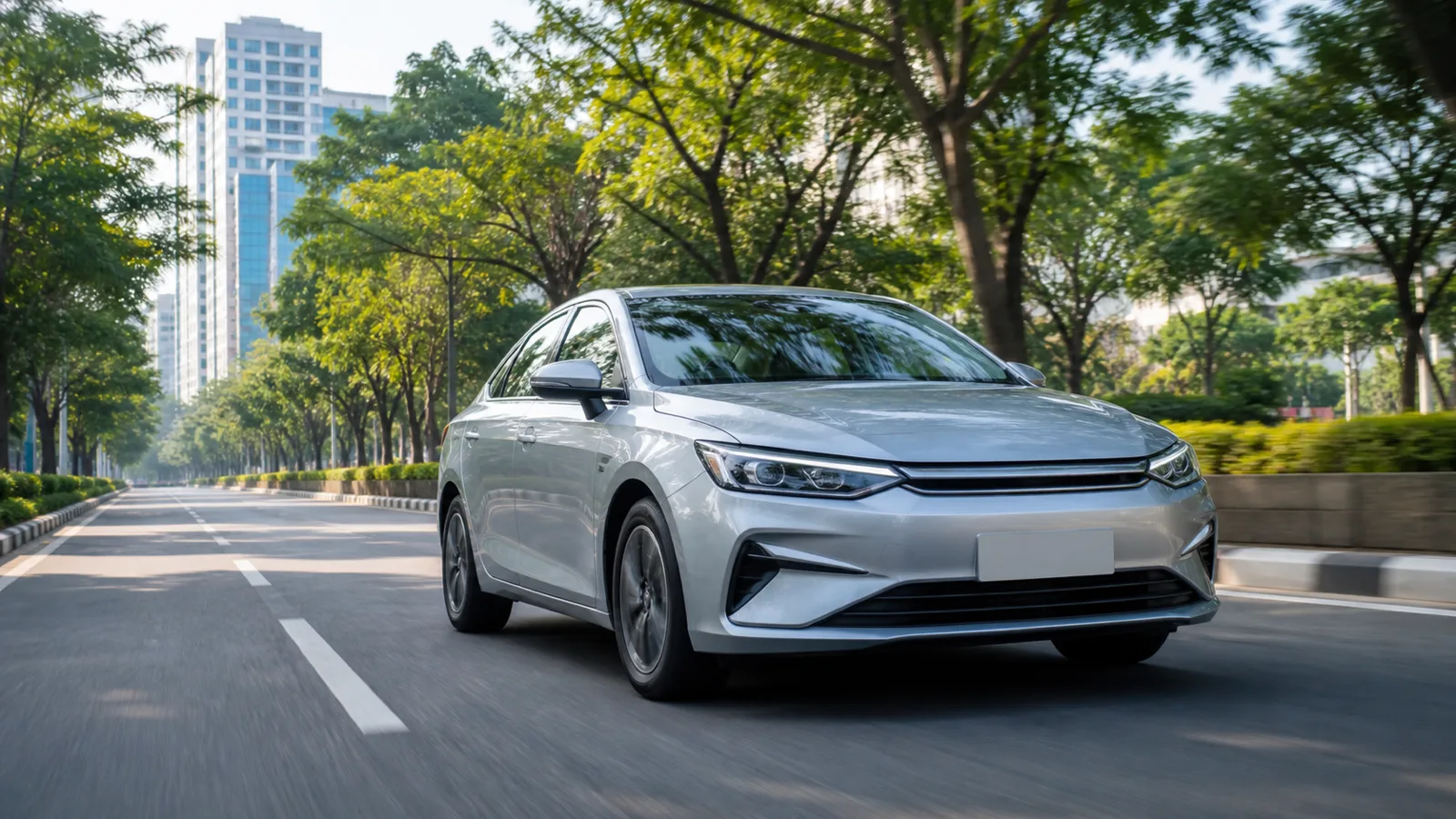 Fuel-efficient silver sedan driving on a tree-lined city road