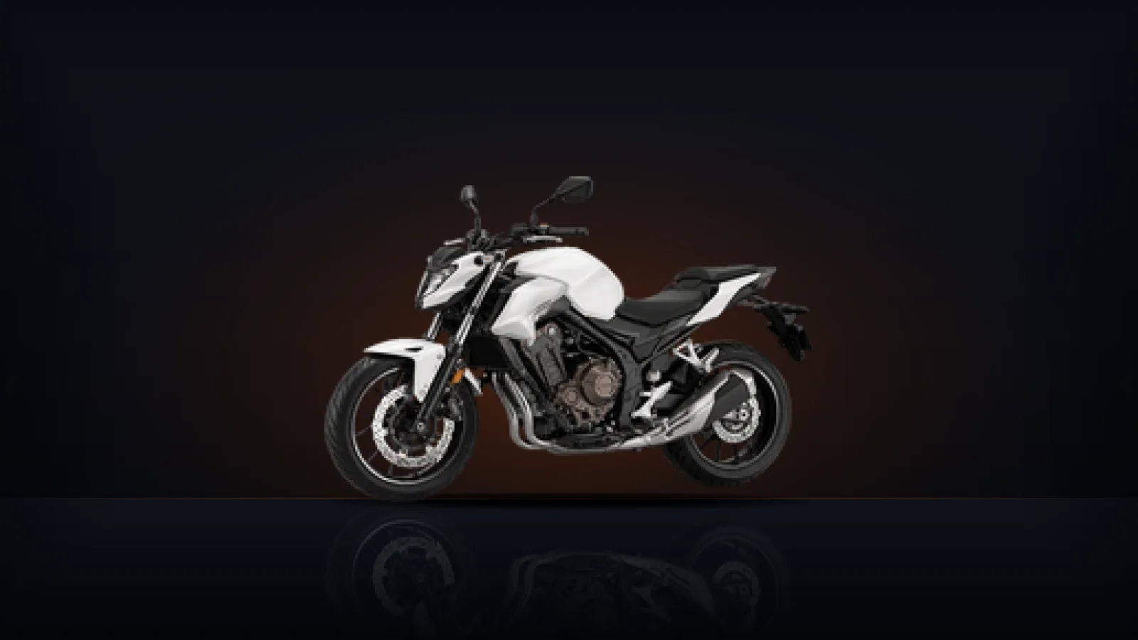 A white naked motorcycle seen from the side, its fuel tank prominent