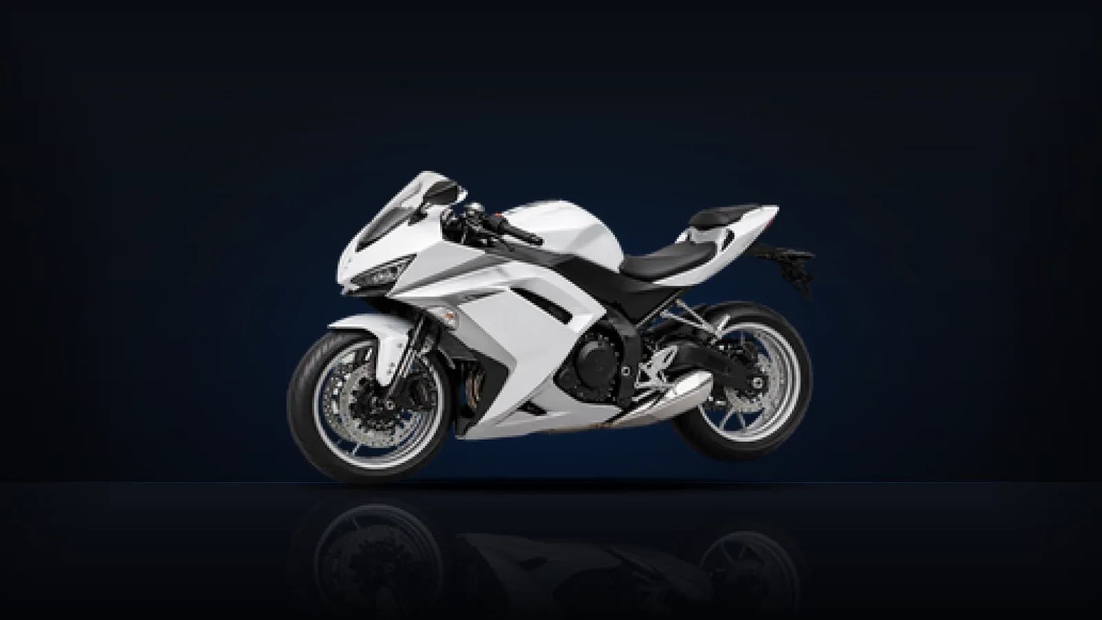 A white sport motorcycle with twin front disc brakes, lit from behind