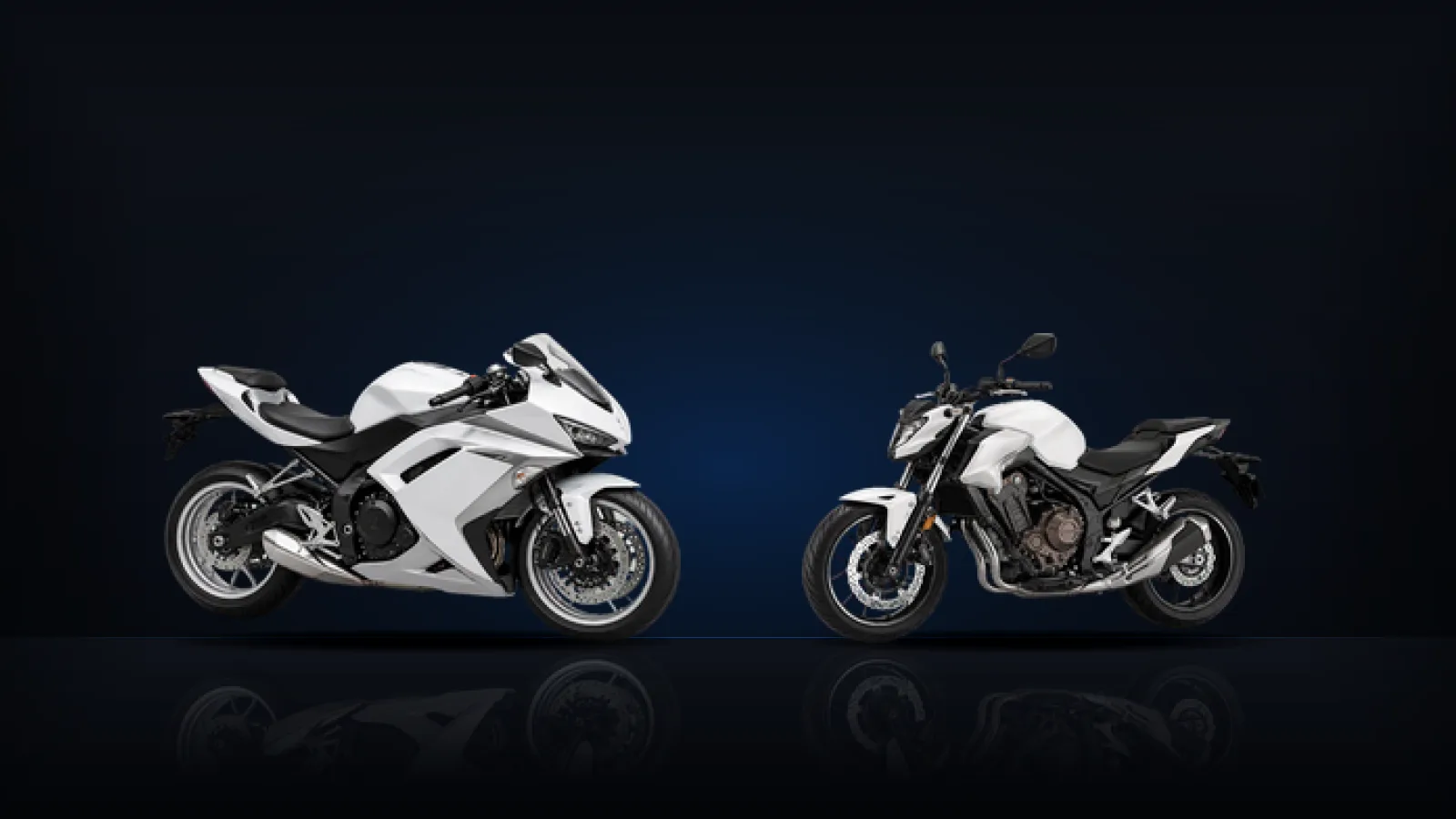 A white faired sport motorcycle and a white naked motorcycle facing each other